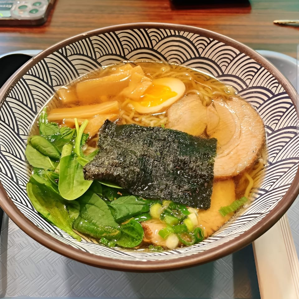A bowl of Kailani ramen with pork, egg, bamboo shoots, spinach, seaweed, and green onions.